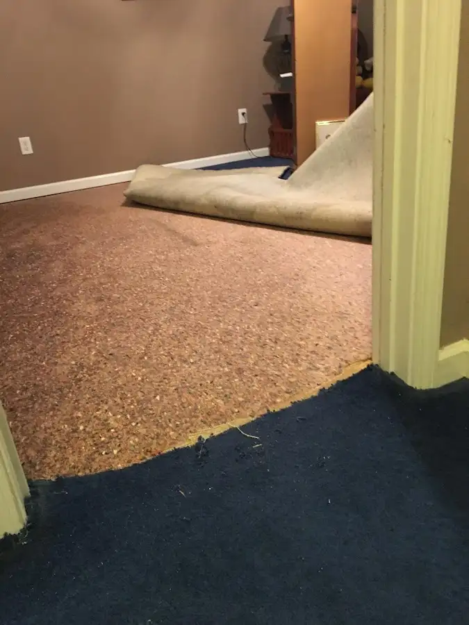 Carpet pad removal revealing water damage during Water Mitigation Services in Carencro